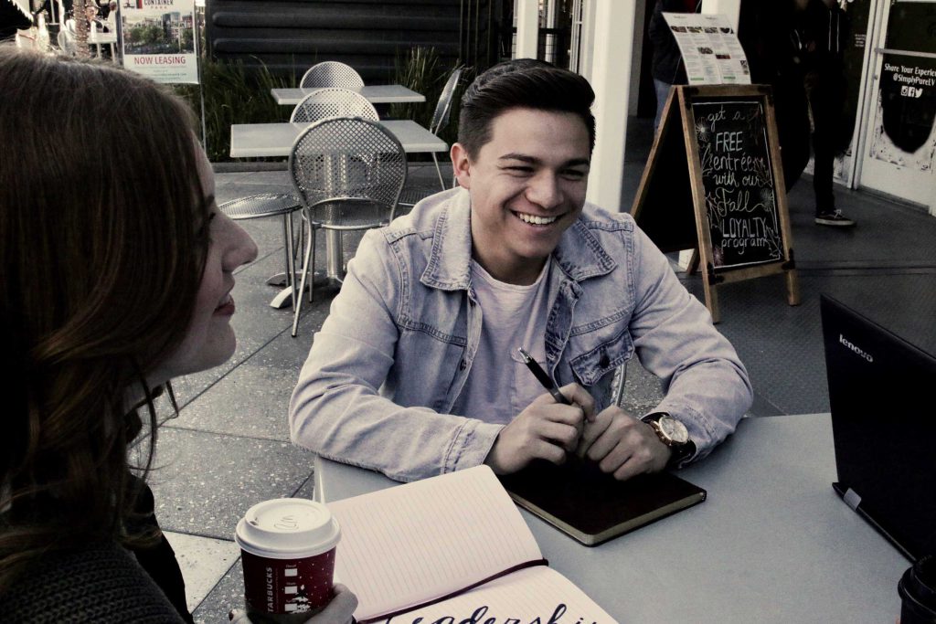 young man sitting at table with friends